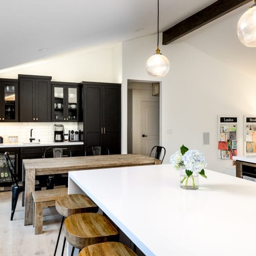 White kitchen countertop with wooden bench style seating