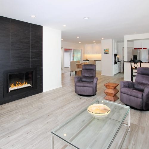 Living room with black tile fireplace and glass coffee table
