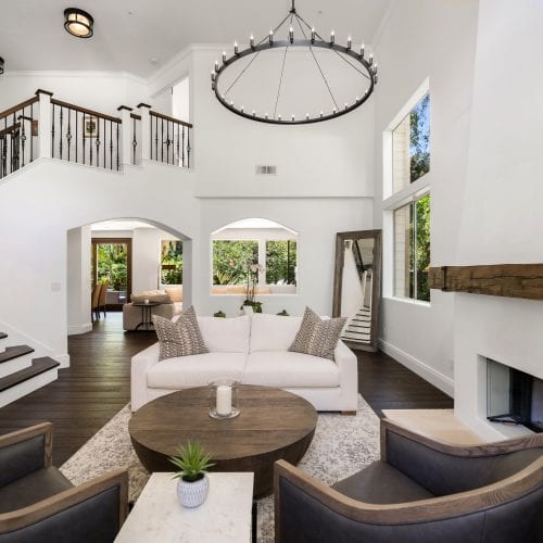 Wide shot of living room with white couch and brown chairs