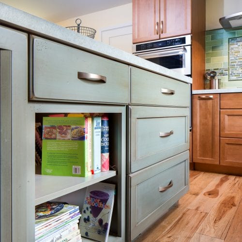 Shelves in kitchen island with cookbooks on them