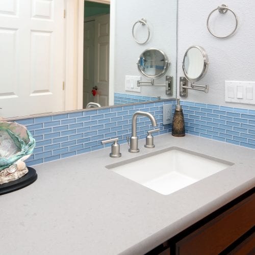 Light blue tile wall accent under large mirror