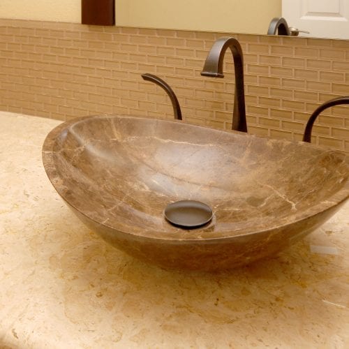 Marbled sink bowl with dark metal faucet