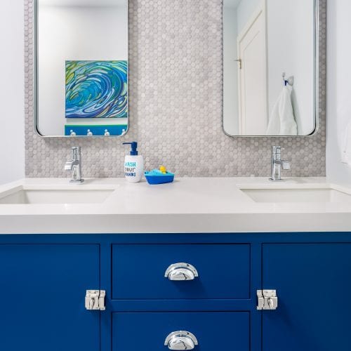 Blue wooden cabinets with dual rectangular mirrors