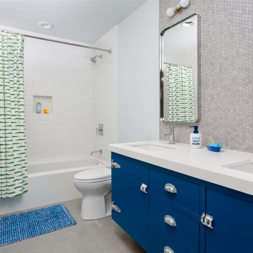 Blue cabinets in bathroom under white marble counter