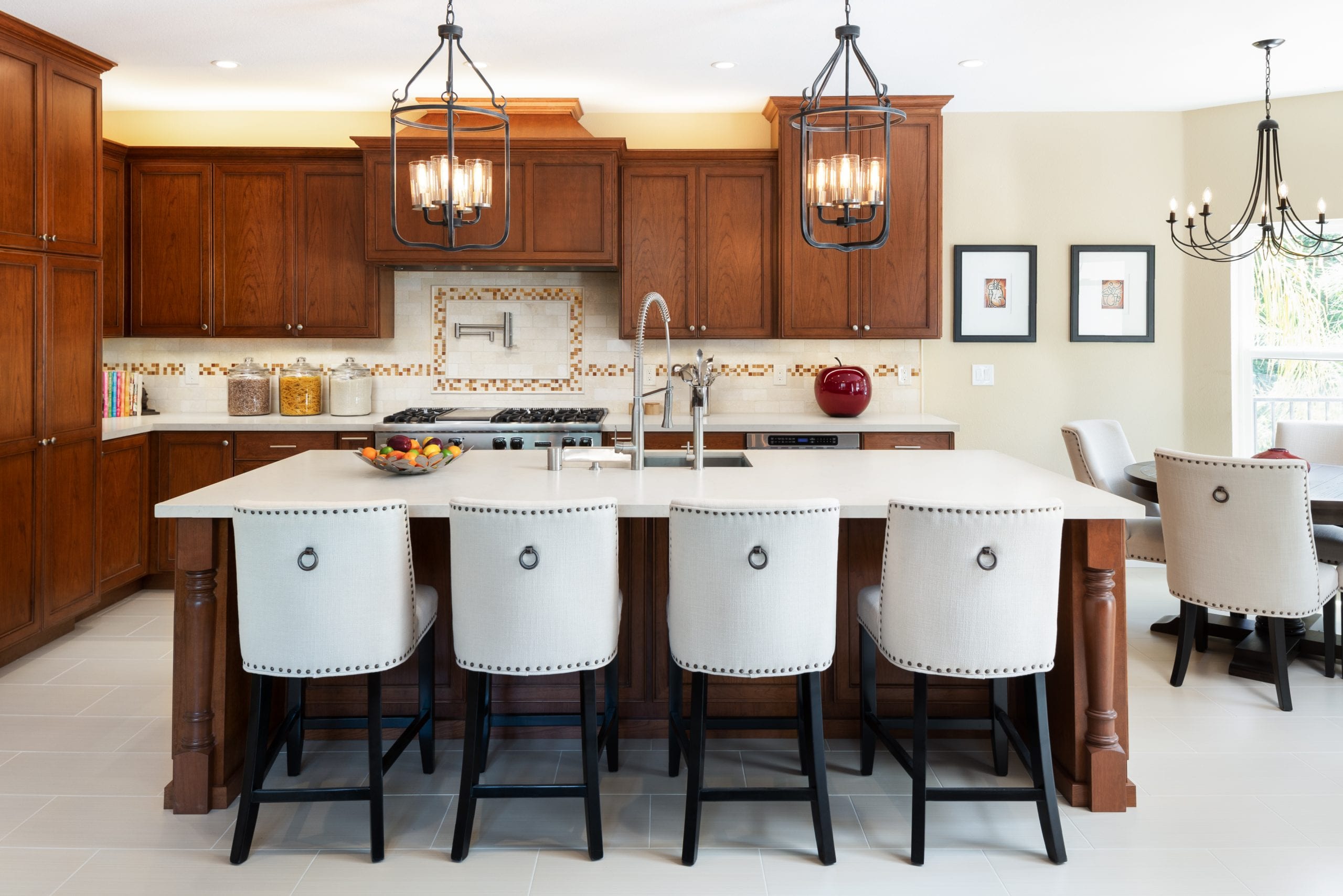 White leather high-back chairs in front of island with white marble countertop