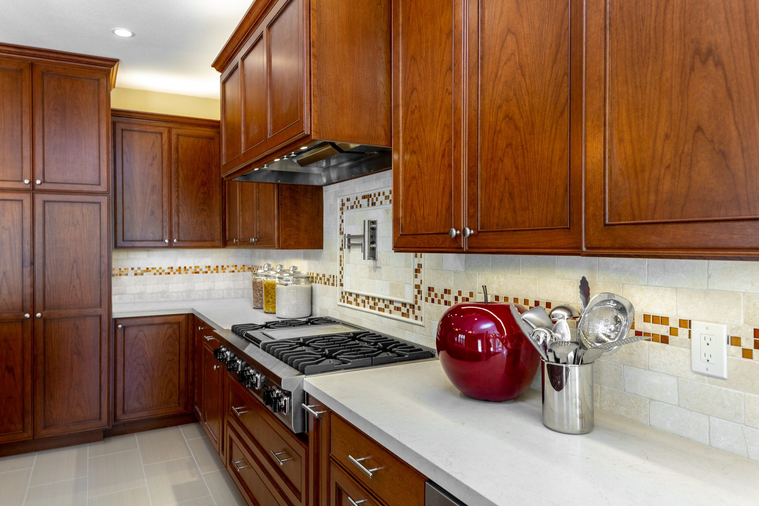 Stovetop with wood and bronze exhaust hood above