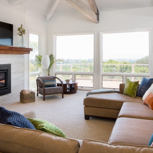 Living space with brown leather couch and large rectangular windows