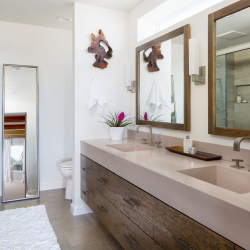 Bathroom with clay colored countertop and wooden framed mirrors