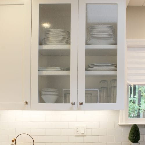 White kitchen cabinet featuring two large glass panes