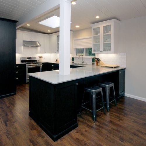 Modern kitchen with black cabinetry and white countertops