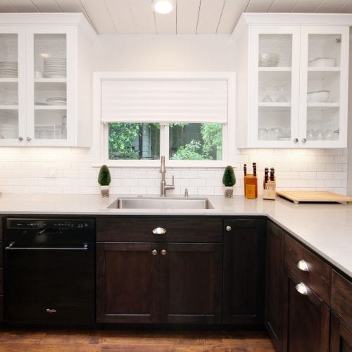 Kitchen countertop featuring two white cabinets with glass panes