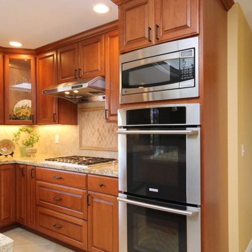 Stainless steel microwave and oven embedded in a wooden cabinet