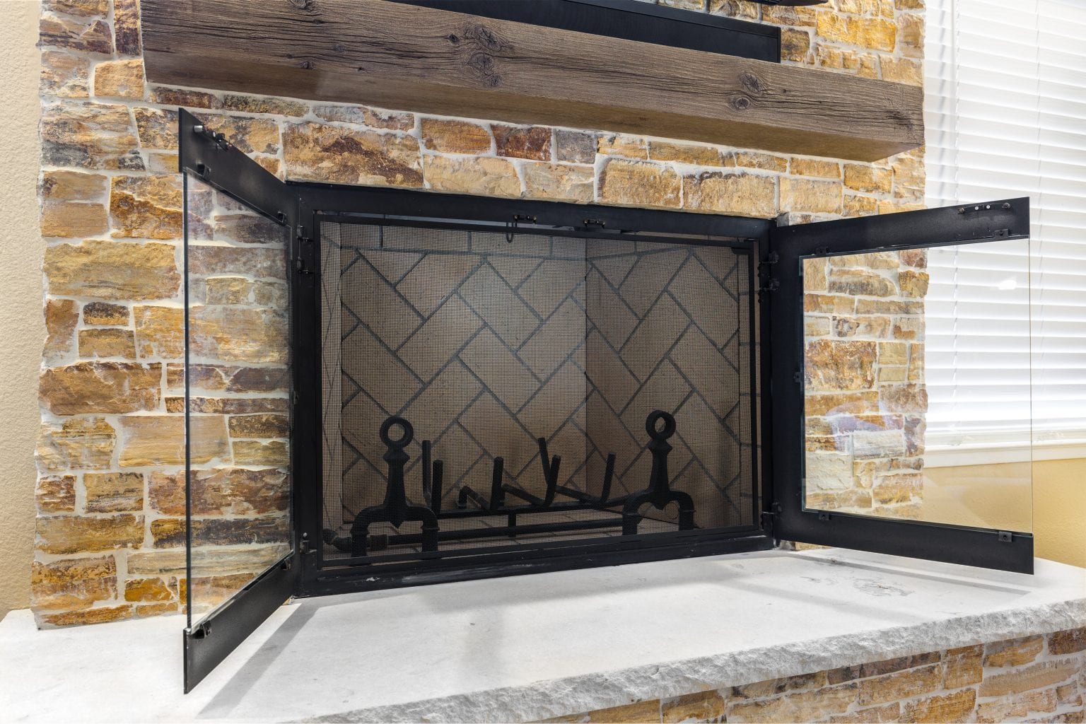 Stone fireplace with black mesh cover