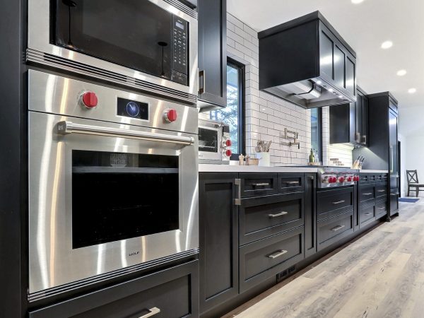 Modern kitchen with black cabinets and stainless steel appliances