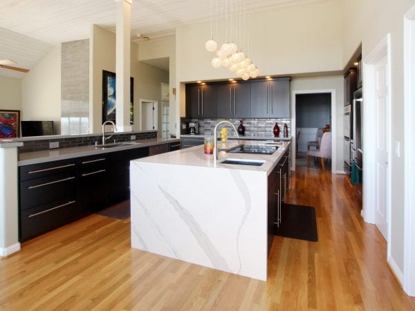 Kitchen remodel with open footprint, black cabinets and a white island