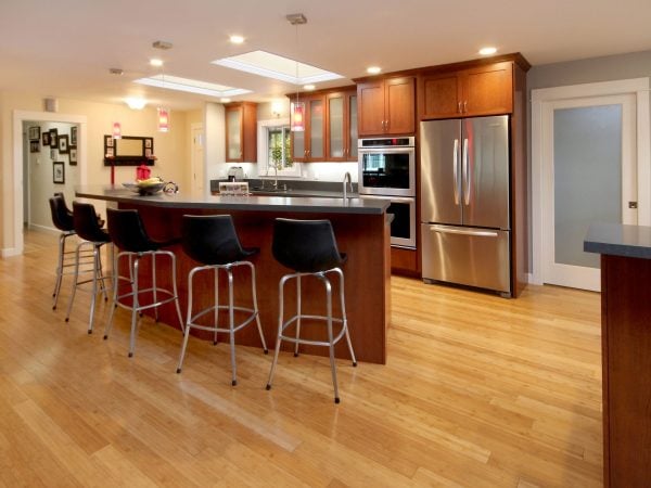 Kitchen with soft lighting, wooden cabinets, and an island with barstools