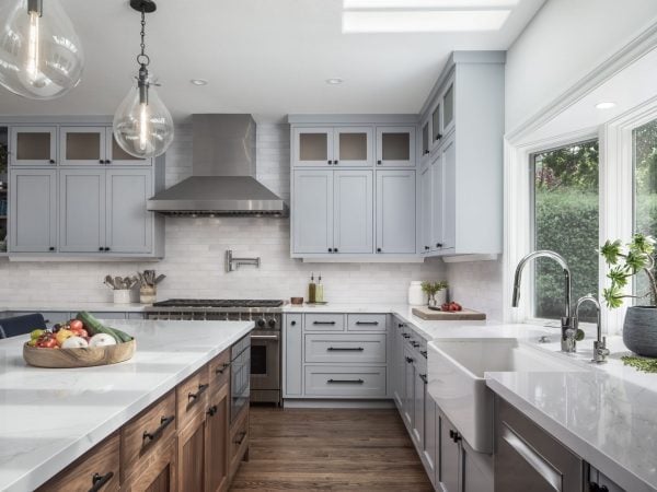 Kitchen with pale blue cabinets and a stand-alone island with a white countertop