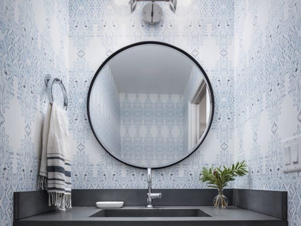 Large and round bathroom mirror with cool colors on the wall