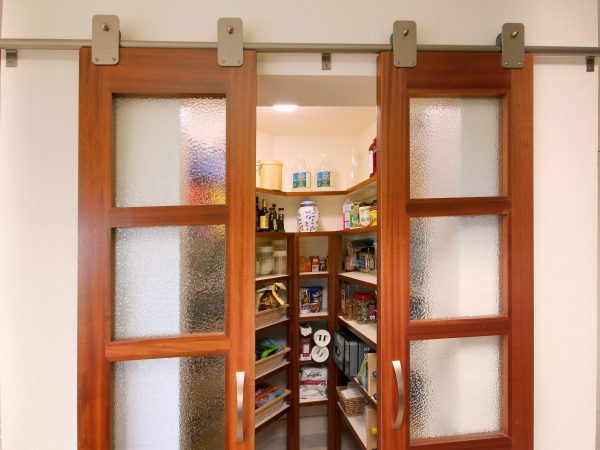 Closet with two wooden and glass sliding doors.