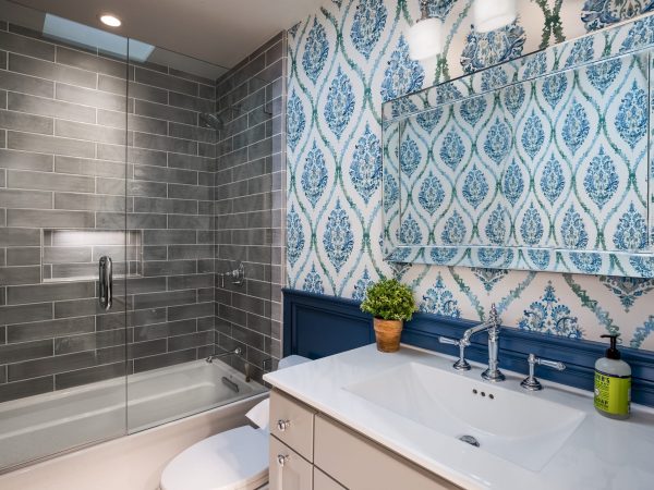 Bathroom with blue patterned wall paper and glass sliding doors