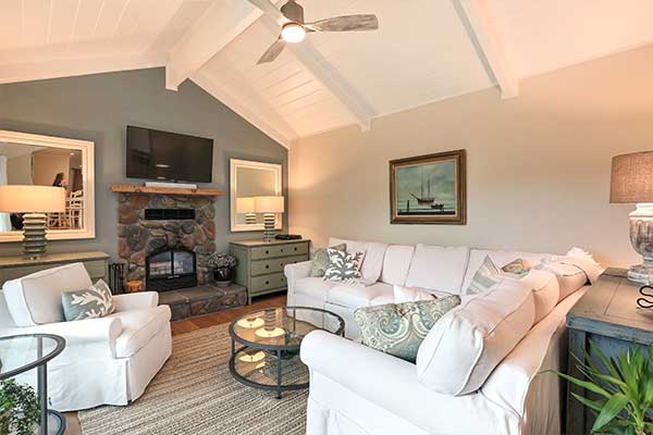 Living room with white furniture and a cathedral style ceiling