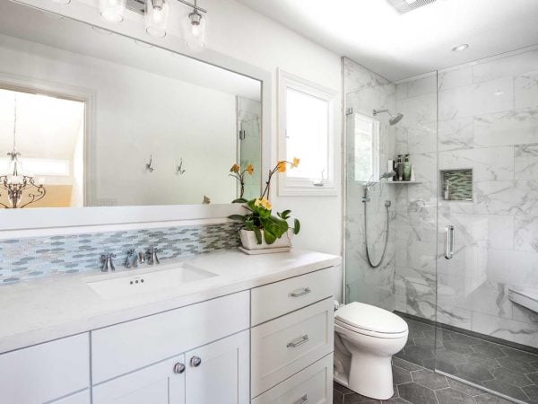 Bathroom remodel with a large mirror and a glass sliding door