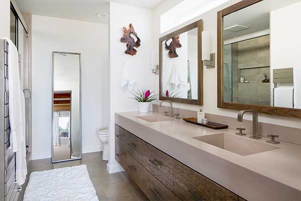 Bathroom with wooden framed mirrors and quartzite countertop