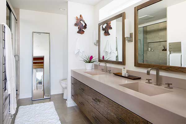 Bathroom with wooden framed mirrors and quartzite countertop